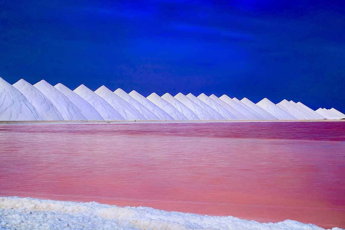 Ervaar de Privé Zuid Tour (Bonaire), waar levendig roze water contrasteert met witte zoutheuvels onder een diepblauwe hemel, met prachtige geometrische vormen en een onvergetelijk landschap.